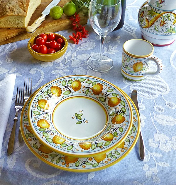 A table set with a Pardi Damasco tablecloth, the Limoni dinnerware and the Primizia mug. All the ceramics are handmade in Deruta, Italy.