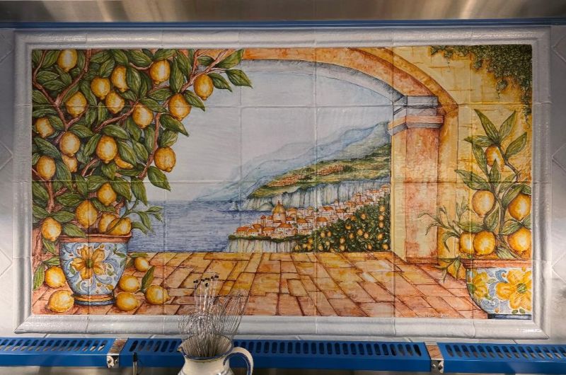 Hand-painted Italian backsplash panel featuring a beautiful Italian coastal landscape adorned with lemons - close up